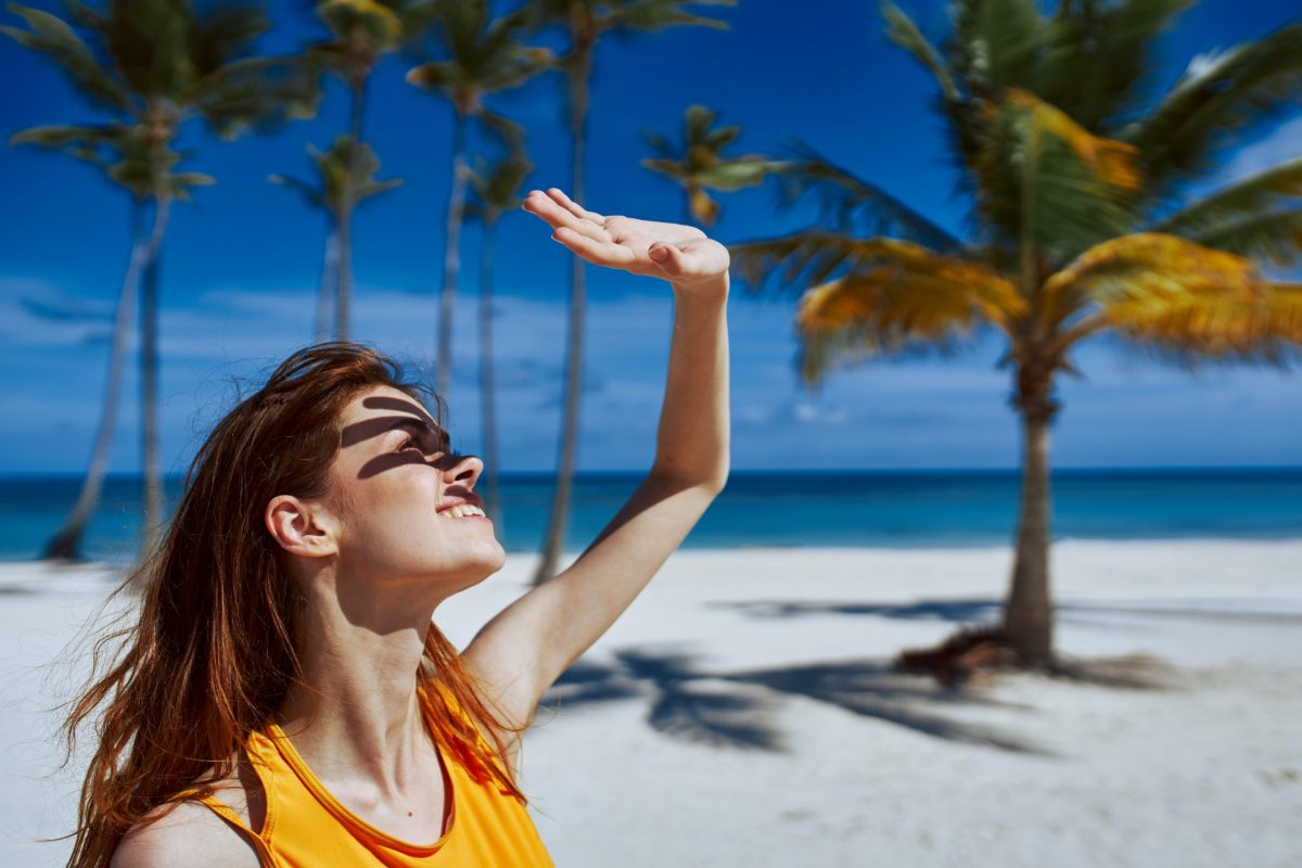woman-covers-her-face-from-the-sun-with-her-hand-on-the-beach-2