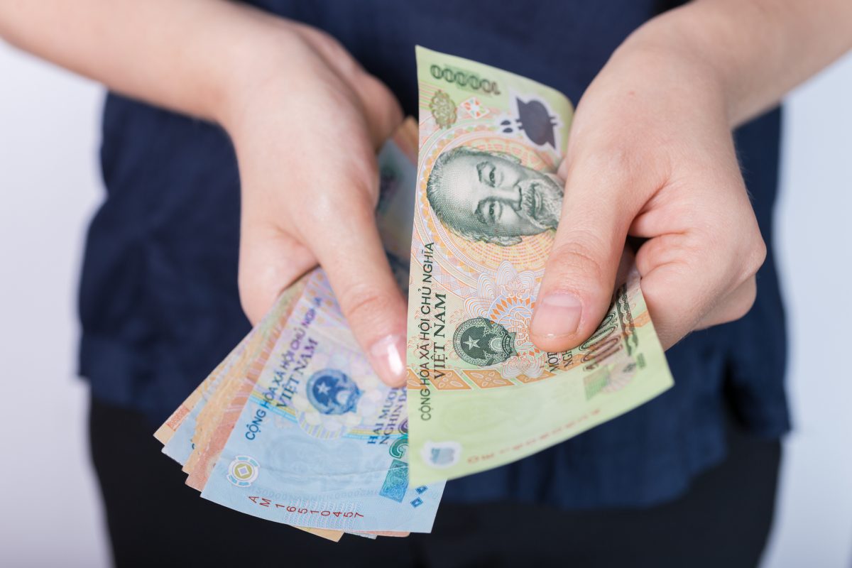 hand-holding-cash-banknote-of-vietnamese-dong-vnd-paying-bills-payment-procedure-or-bribe-salary