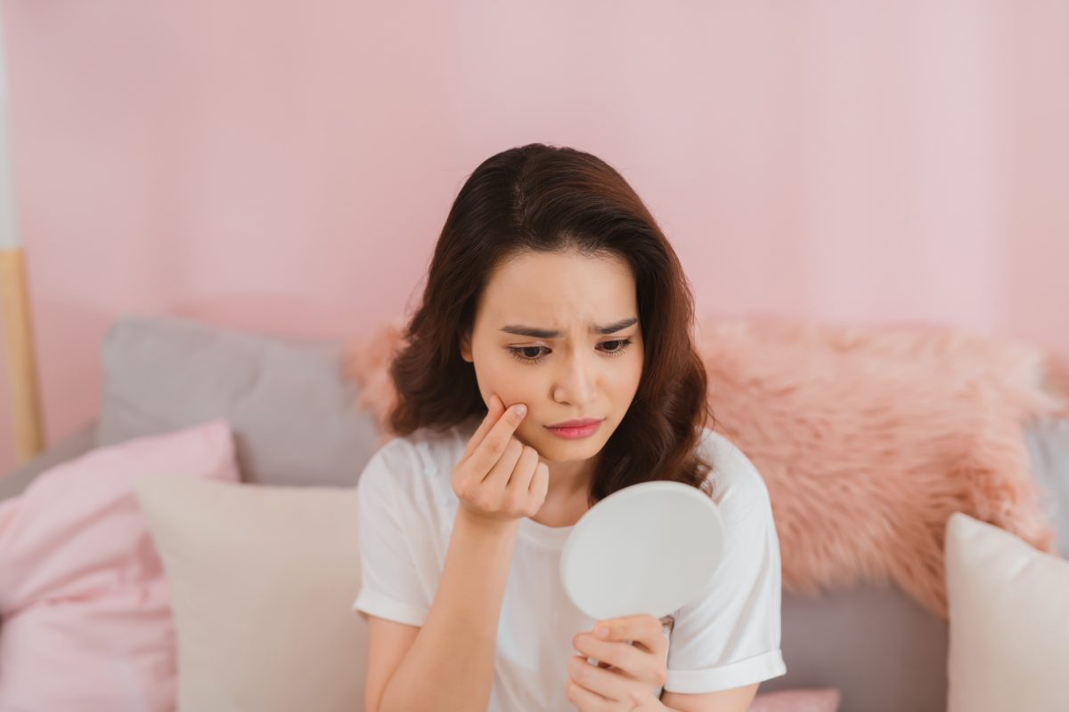 woman-look-mirrior-feel-upset-and-touch-her-face-with-acne-problem