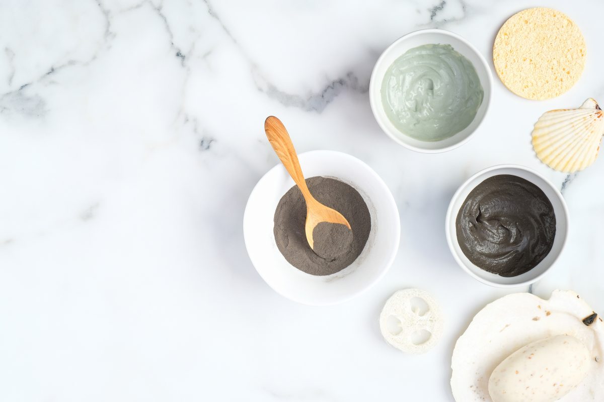 flat-lay-facial-clay-mask-homemade-soap-loofah-sponge-on-marble-background-top-view-natural-organic-spa-cosmetic-products-for-skincare-body-and-hair-care-concept
