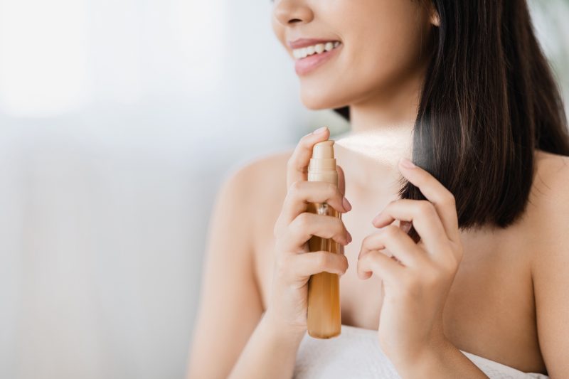 closeup-of-asian-girl-using-hair-spray-copy-space