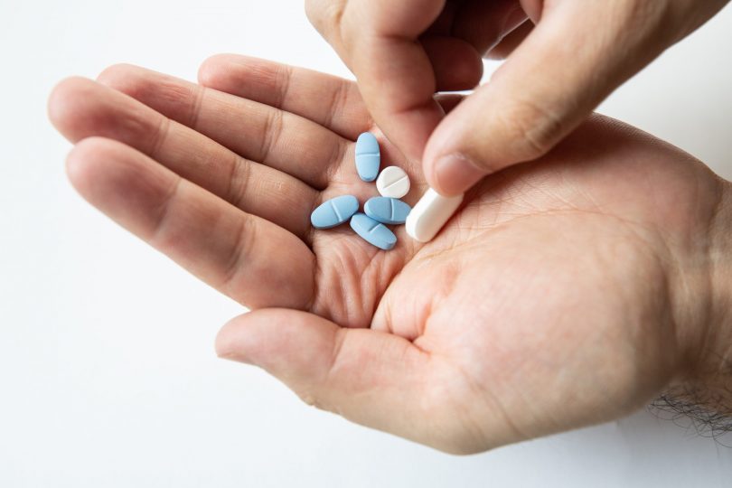 different-pills-in-male-hand-isolate