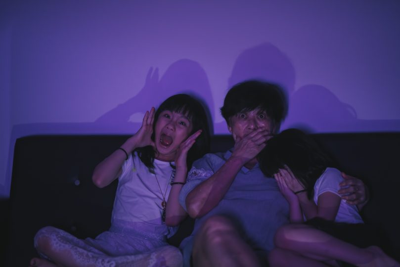 asian-chinese-senior-woman-watching-horror-movie-with-her-grandchildren
