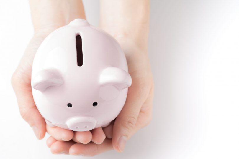 top-view-of-young-female-hands-tender-holding-pink-piggy-bank-on-white-table-in-soft-tone-savings-and-invest-for-future-growth