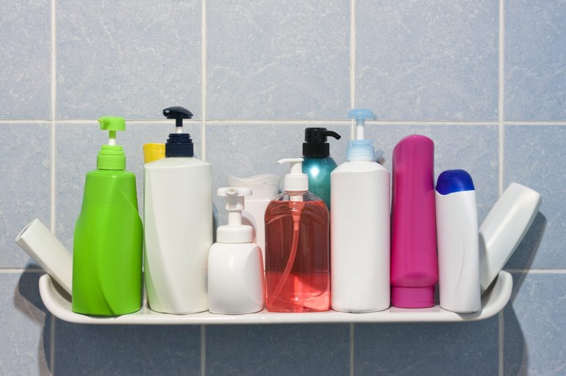 many-shampoo-and-soap-bottles-on-a-bathroom-shelf