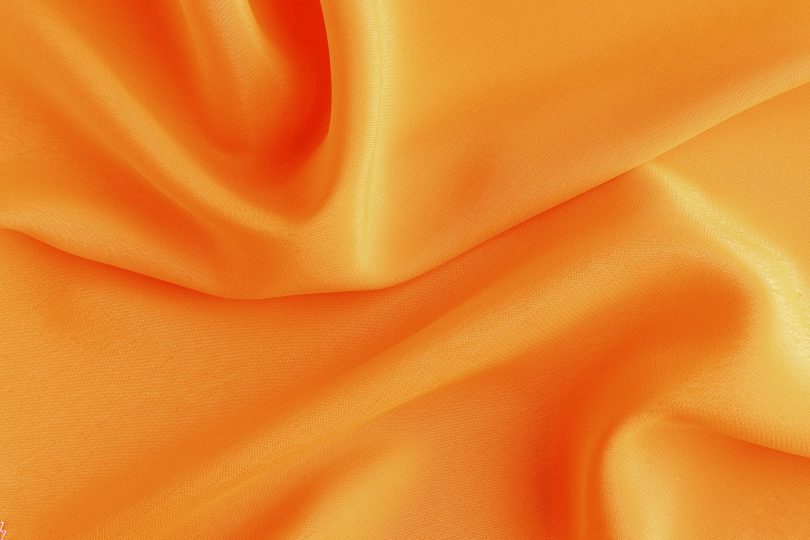 satin-silk-fabric-orange-color-for-the-background-crumpled-wavy-silk-texture-of-satin-fabric