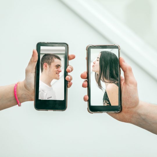 millennial-couple-kissing-via-mobile-devices