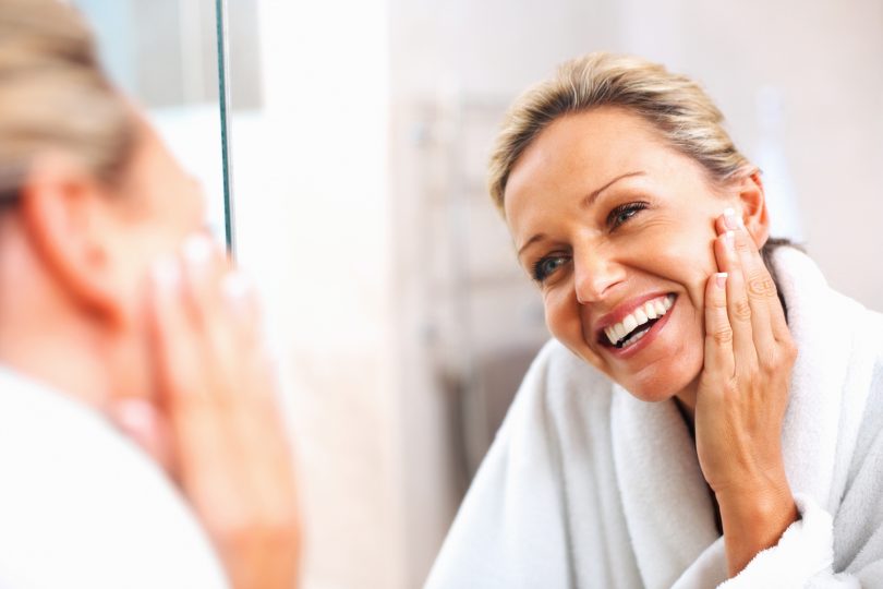 happy-mature-woman-admiring-herself-in-the-mirror