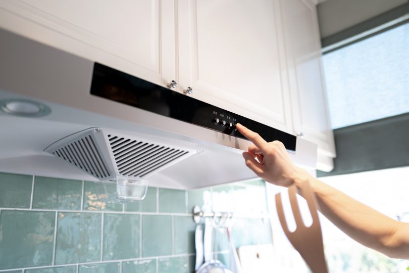 human-hand-pushing-the-button-of-the-kitchen-range-hood