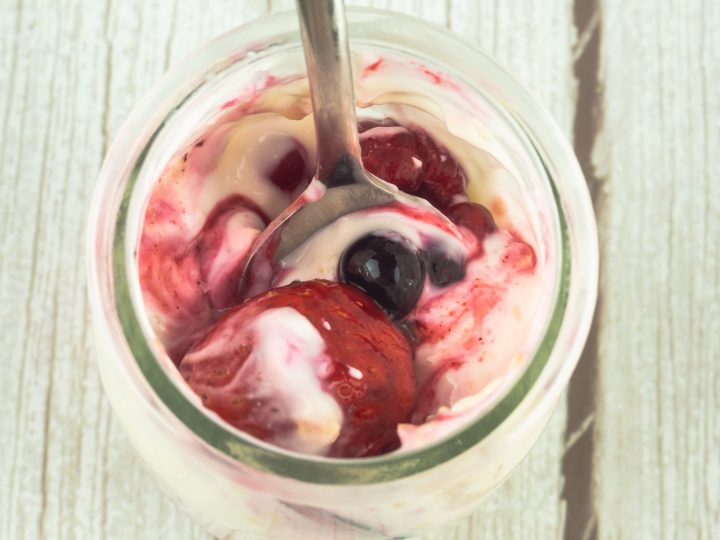 top-view-of-a-glass-of-yogurt-with-berries-and-a-spoon
