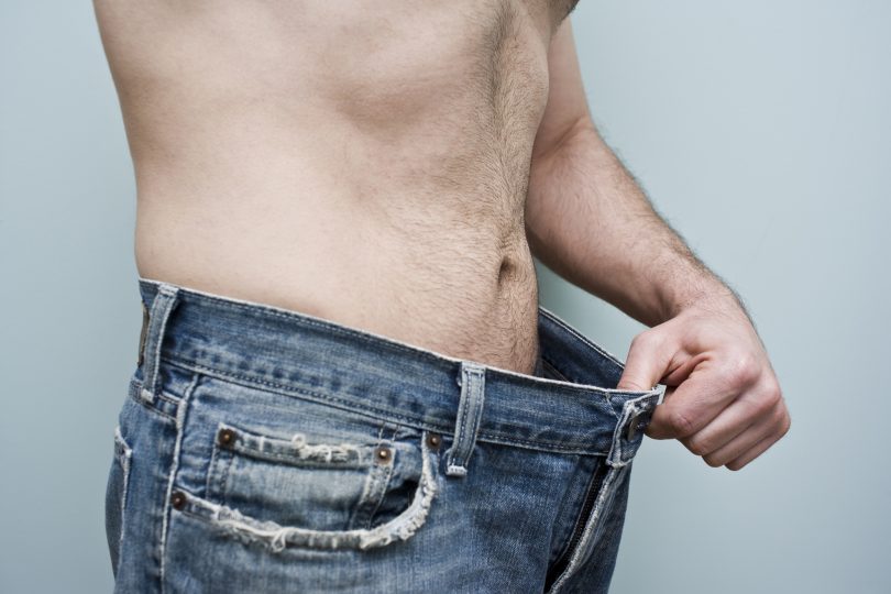 man-showing-weight-loss-by-showing-his-loose-pants