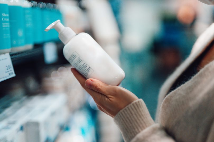 close-up-shot-of-female-hand-holding-hand-cream-bottle-in-supermarket-3