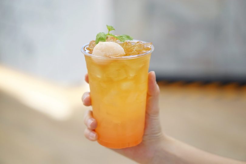 a-plastic-glass-of-iced-lychee-rose-cold-brew-tea-on-blurred-background-perfect-drink-for-summer-time