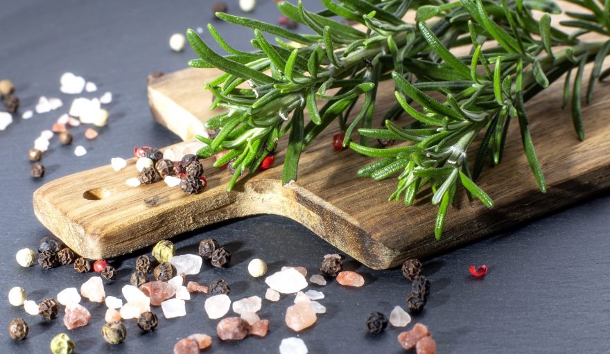 bunch-of-fresh-organic-basil-on-wooden-cutting-board-with-pepper-and-salt-on-black-background