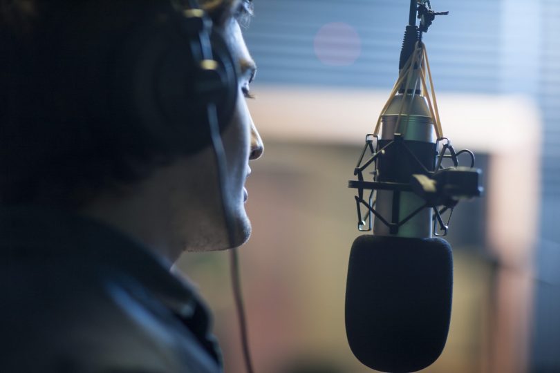 male-musician-in-recording-studio-singing-into-microphone