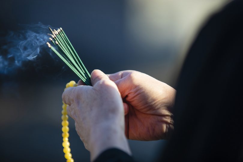 a-funeral-in-japan-and-a-visit-to-a-grave-senior-women-have-beads-and-incense-sticks-wearing-black-mourning-smoke-comes-out-from-the-incense-stick