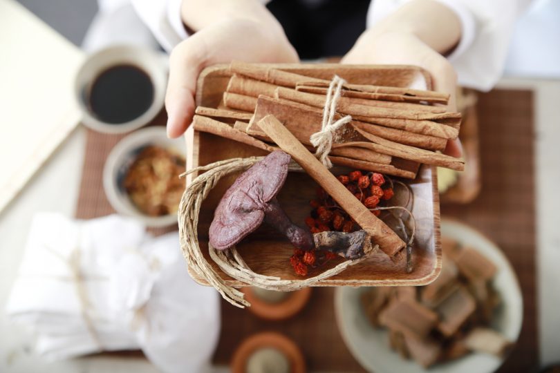 oriental-medical-doctor-hand-holding-plate-with-herbal-medicine
